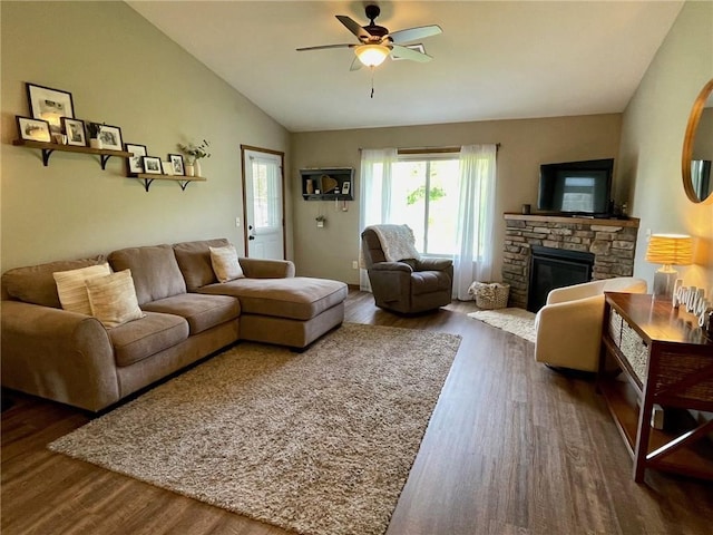 4010 Nicholas Dr, Menomonie, WI 54751 - living room featuring dark wood finished floors, a ceiling fan, a stone fireplace, and vaulted ceiling