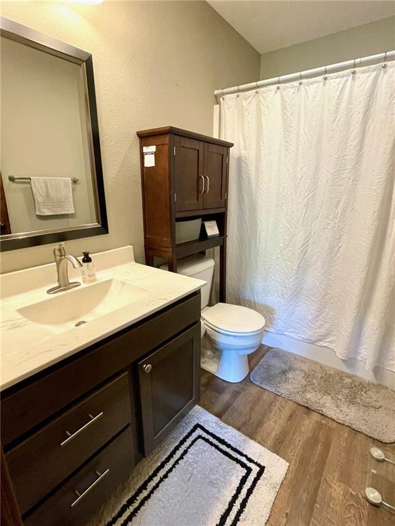 4010 Nicholas Dr, Menomonie, WI 54751 - bathroom featuring wood finished floors, toilet, and vanity