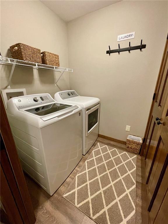 4010 Nicholas Dr, Menomonie, WI 54751 - laundry area featuring independent washer and dryer, light wood-style floors, and baseboards