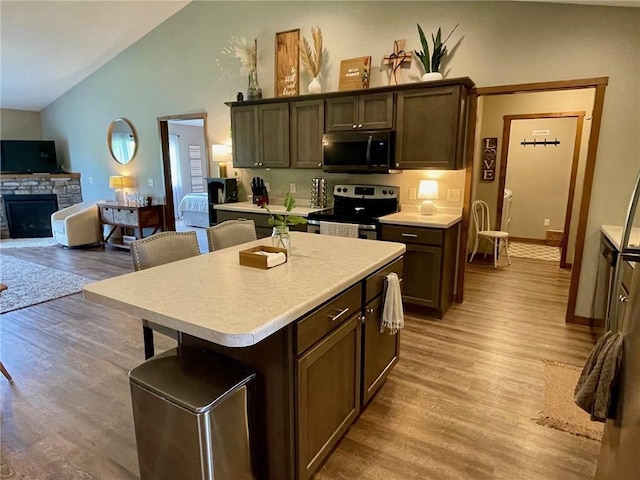 4010 Nicholas Dr, Menomonie, WI 54751 - kitchen featuring appliances with stainless steel finishes, light countertops, light wood-type flooring, and high vaulted ceiling