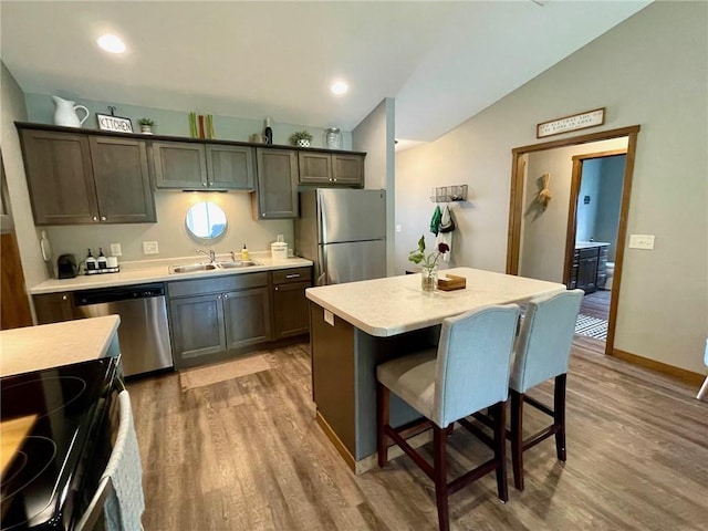 4010 Nicholas Dr, Menomonie, WI 54751 - kitchen with stainless steel appliances, a sink, lofted ceiling, light countertops, and wood finished floors