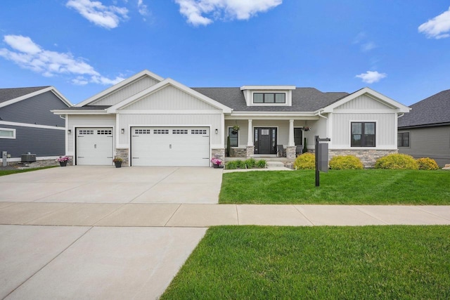 6249 Fountainhead Cir, Deforest, WI 53532 - craftsman-style house featuring stone siding, covered porch, an attached garage, driveway, and a front lawn
