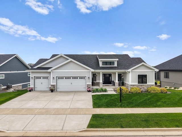 6249 Fountainhead Cir, Deforest, WI 53532 - craftsman-style house with stone siding, a porch, a front lawn, driveway, and an attached garage