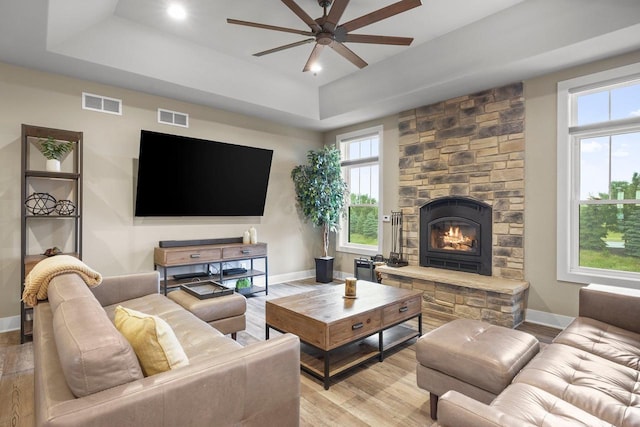 6249 Fountainhead Cir, Deforest, WI 53532 - living area featuring a raised ceiling, a ceiling fan, baseboards, light wood finished floors, and a fireplace