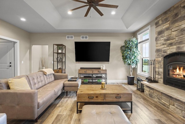 6249 Fountainhead Cir, Deforest, WI 53532 - living room featuring hardwood / wood-style flooring, ceiling fan, a raised ceiling, baseboards, and a stone fireplace