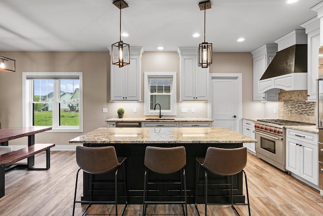 6249 Fountainhead Cir, Deforest, WI 53532 - kitchen with premium stove, a sink, premium range hood, a kitchen island, and tasteful backsplash