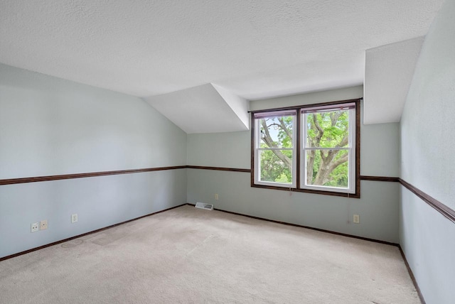 6262 W College Ave, Greendale, WI 53129 - bonus room with carpet, a textured ceiling, baseboards, and lofted ceiling