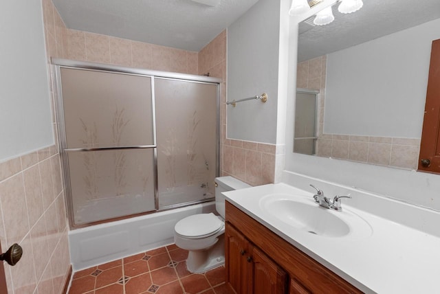 6262 W College Ave, Greendale, WI 53129 - bathroom featuring tile walls, vanity, combined bath / shower with glass door, toilet, and tile patterned floors