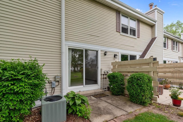 6262 W College Ave, Greendale, WI 53129 - rear view of house featuring central AC unit, a chimney, and a patio