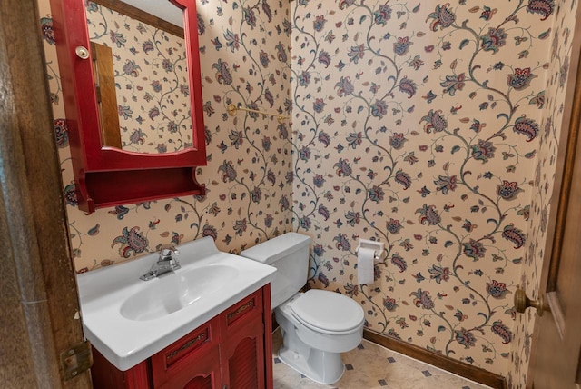 6262 W College Ave, Greendale, WI 53129 - half bathroom featuring wallpapered walls, toilet, vanity, and baseboards