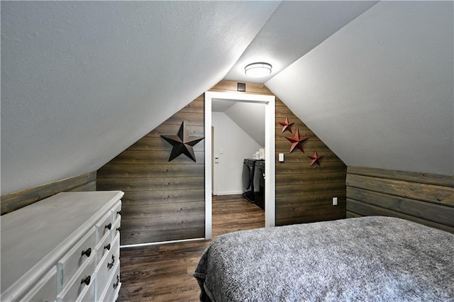 54675 Cudworth Ave, Grand View, WI 54839 - bedroom featuring wood walls, washer and dryer, a textured ceiling, lofted ceiling, and dark wood finished floors