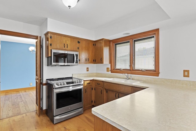 1615 Hickory St, South Milwaukee, WI 53172 - kitchen featuring appliances with stainless steel finishes, light countertops, brown cabinets, and light wood finished floors