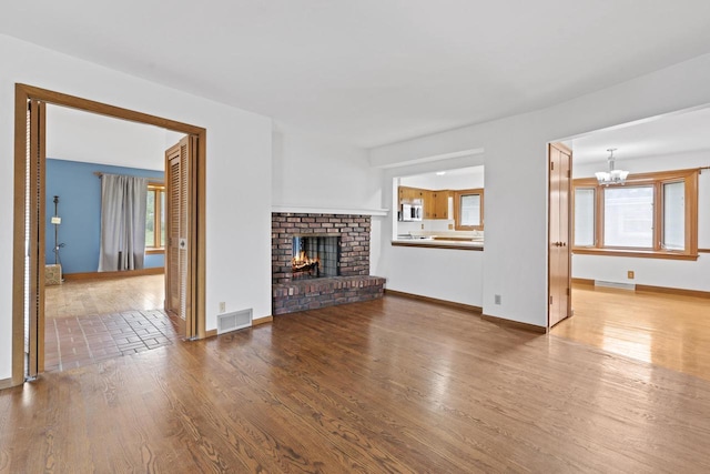 1615 Hickory St, South Milwaukee, WI 53172 - unfurnished living room with a chandelier, wood finished floors, and a fireplace