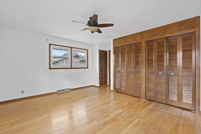 1615 Hickory St, South Milwaukee, WI 53172 - unfurnished bedroom featuring light wood-type flooring, two closets, and a ceiling fan