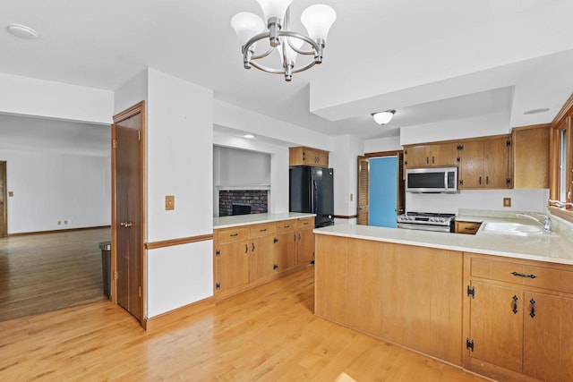1615 Hickory St, South Milwaukee, WI 53172 - kitchen with stainless steel appliances, a chandelier, light countertops, and light wood finished floors