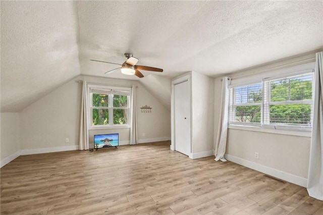 2256 40th Ave Unit X, Osceola, WI 54020 - additional living space with a textured ceiling, ceiling fan, plenty of natural light, light wood-style flooring, and vaulted ceiling