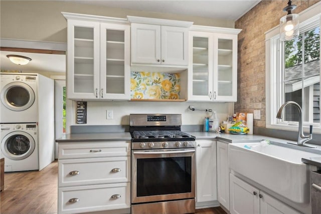 2256 40th Ave Unit X, Osceola, WI 54020 - kitchen with gas stove, stacked washer / drying machine, white cabinetry, glass insert cabinets, and wood finished floors