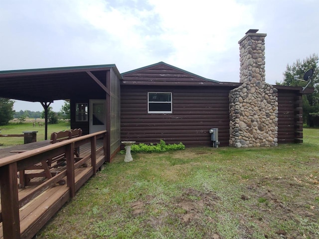 W5677 Alice Ln, New Lisbon, WI 53950 - view of home's exterior with log veneer siding, a yard, and a chimney