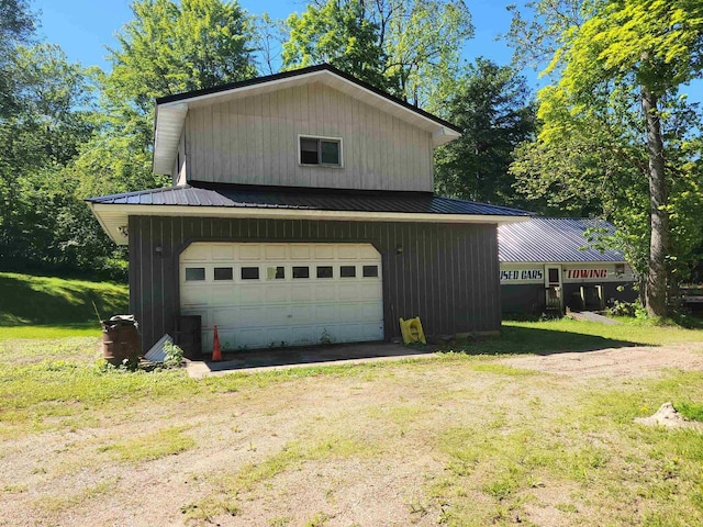 W2671 State Highway 64 E, White Lake, WI 54491 - view of property exterior featuring a detached garage, a lawn, and metal roof