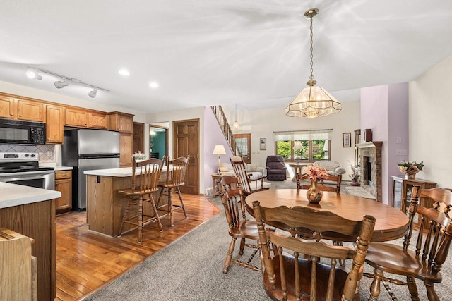 N7844 Lake Shore Ln, Sherwood, WI 54169 - dining space with a chandelier, light wood-style flooring, and a brick fireplace