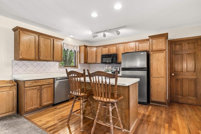 N7844 Lake Shore Ln, Sherwood, WI 54169 - kitchen featuring stainless steel appliances, wood-type flooring, brown cabinets, a kitchen island, and recessed lighting