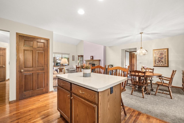 N7844 Lake Shore Ln, Sherwood, WI 54169 - kitchen with light wood-style floors, a kitchen island, a kitchen bar, a fireplace, and light countertops