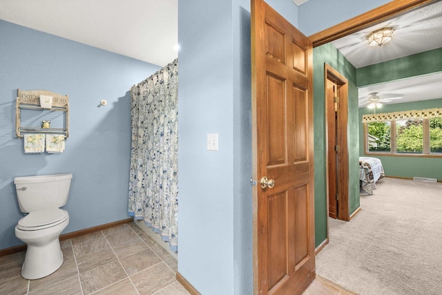 N7844 Lake Shore Ln, Sherwood, WI 54169 - bathroom with toilet, baseboards, curtained shower, ceiling fan, and ensuite bath