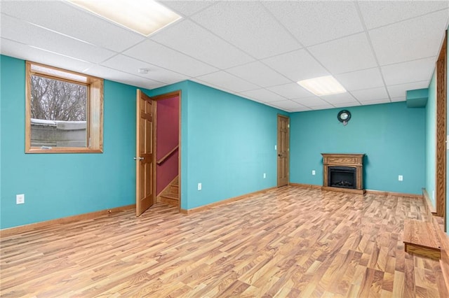 231 S Woodworth St, Elmwood, WI 54740 - unfurnished living room featuring wood finished floors, a drop ceiling, and a fireplace