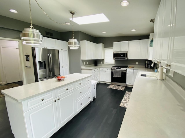 540 W Manor Cir, Bayside, WI 53217 - kitchen with stainless steel appliances, a kitchen island, a skylight, light countertops, and recessed lighting