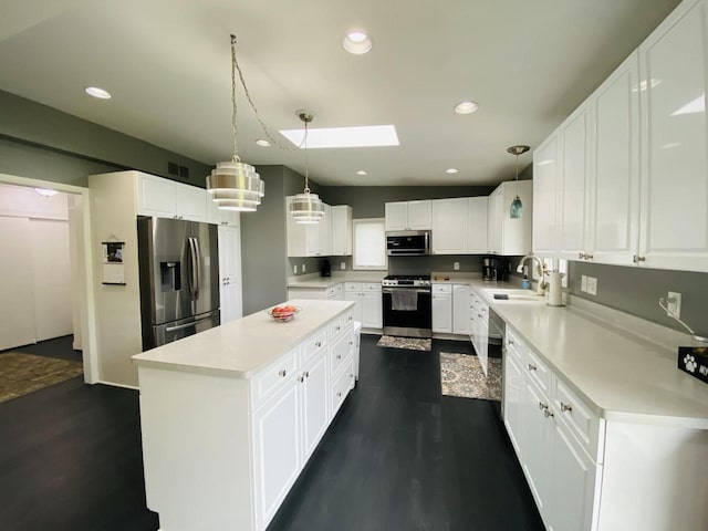 540 W Manor Cir, Bayside, WI 53217 - kitchen featuring stainless steel appliances, dark wood-type flooring, a kitchen island, a skylight, and light countertops