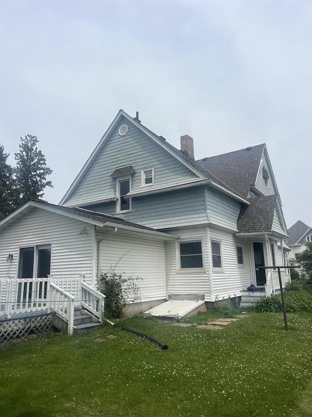 352 N Harrison St, Lancaster, WI 53813 - rear view of property with a chimney, a lawn, a deck, and a shingled roof