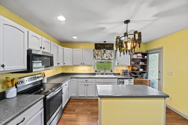 104 Chapel Hill Dr, Johnson Creek, WI 53038 - kitchen with appliances with stainless steel finishes, a sink, wood finished floors, a chandelier, and dark countertops