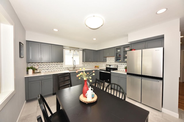 7062 N 46th St, Milwaukee, WI 53223 - kitchen featuring stainless steel appliances, gray cabinets, backsplash, light countertops, and recessed lighting