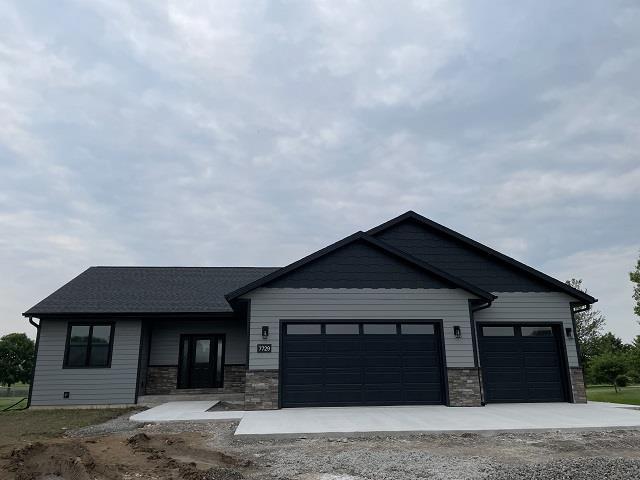7729 Lanae Ave, Hewitt, WI 54441 - view of front of property with a garage, concrete driveway, and stone siding