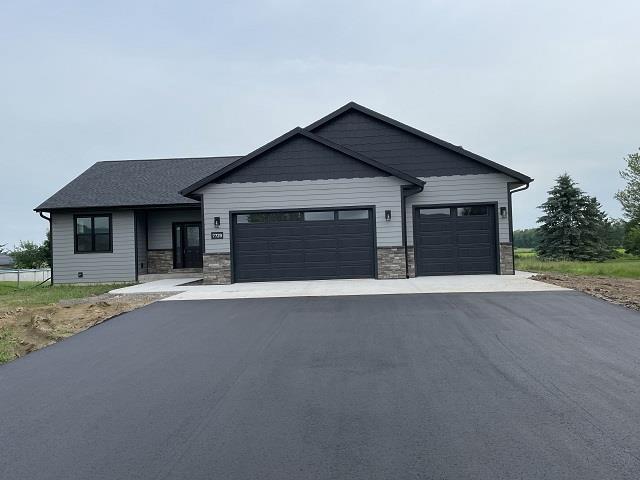 7729 Lanae Ave, Hewitt, WI 54441 - view of front of house featuring a garage, driveway, and stone siding