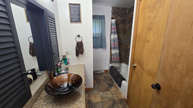 510 N Monroe St, Lancaster, WI 53813 - full bathroom featuring shower / bath combination with curtain, stone finish floors, vanity, and baseboards