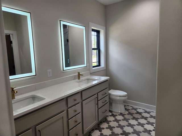 1100 Moll Dr, Waunakee, WI 53597 - bathroom with double vanity, toilet, tile patterned floors, and baseboards