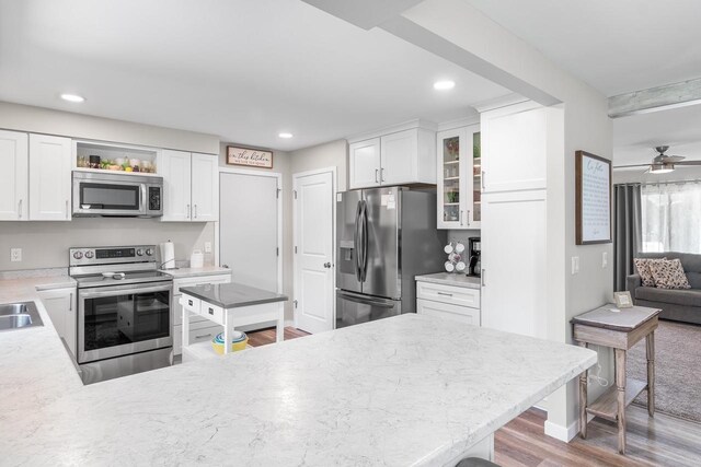 30 Highland Ave, Ripon, WI 54971 - kitchen with appliances with stainless steel finishes, light wood-style flooring, a peninsula, glass insert cabinets, and white cabinetry