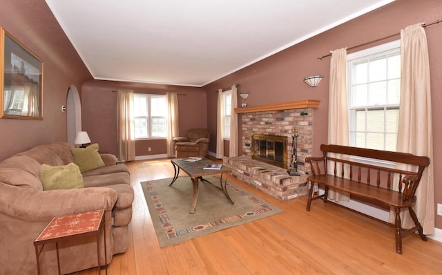 3330 S 47th St, Greenfield, WI 53219 - living area featuring wood finished floors, arched walkways, a brick fireplace, and crown molding