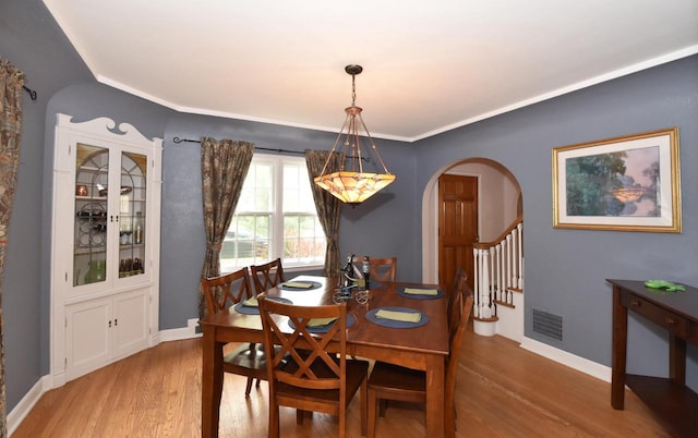 3330 S 47th St, Greenfield, WI 53219 - dining space featuring arched walkways, wood finished floors, and stairs