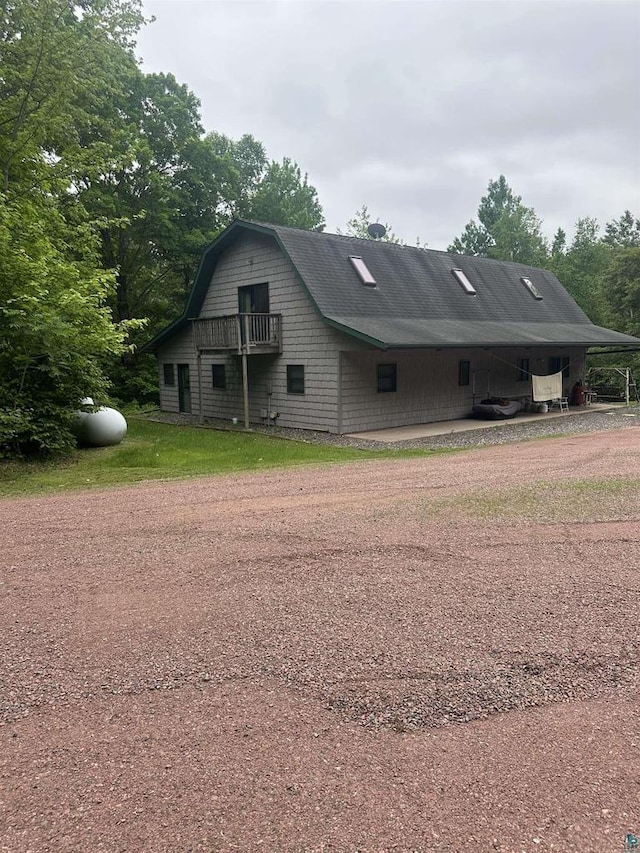 58875 Roy Anderson Rd, Mason, WI 54856 - view of side of property with driveway, a gambrel roof, and an attached carport