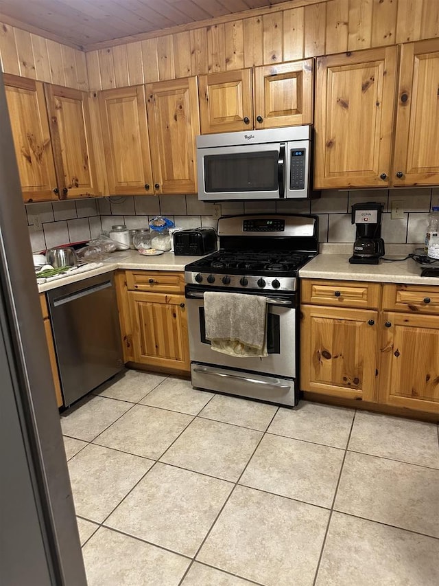 58875 Roy Anderson Rd, Mason, WI 54856 - kitchen with stainless steel appliances, light countertops, brown cabinets, light tile patterned floors, and wooden ceiling