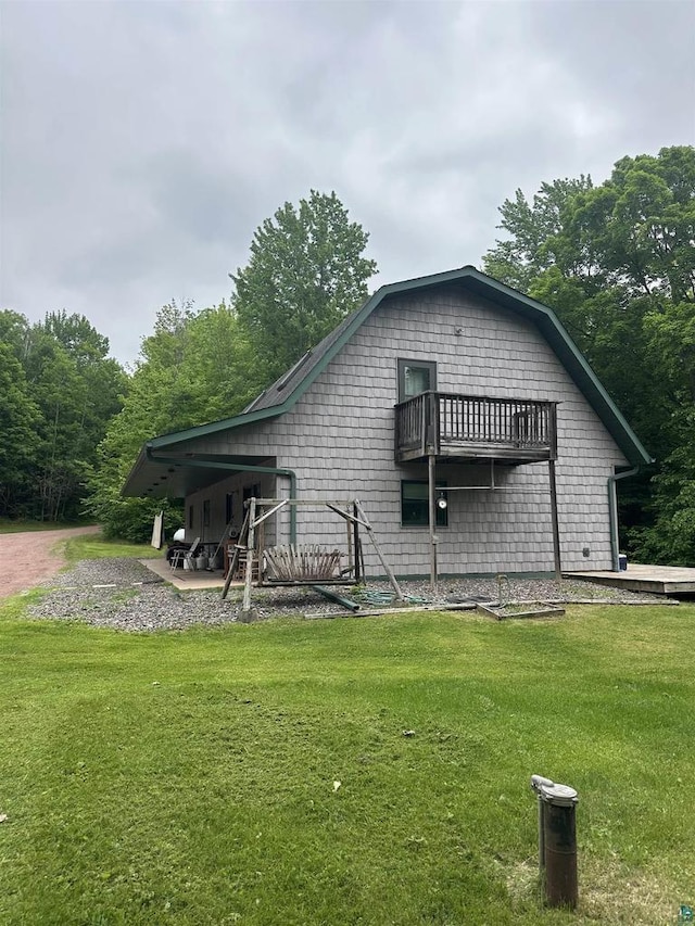 58875 Roy Anderson Rd, Mason, WI 54856 - back of house with a lawn, a balcony, and a gambrel roof