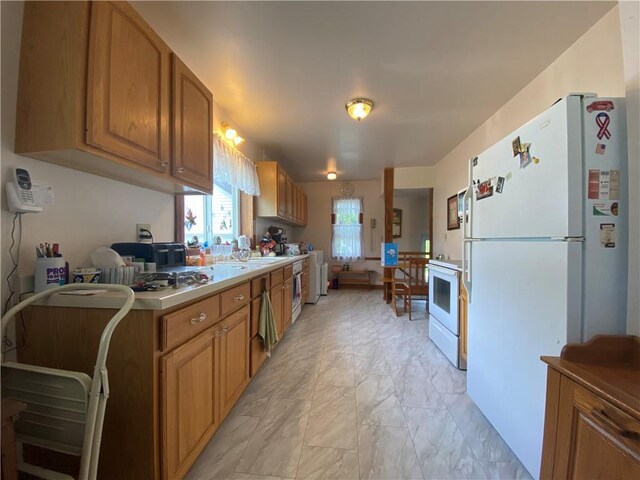 1114 Newman St, Bloomer, WI 54724 - kitchen with white appliances, light marble finish flooring, brown cabinetry, and light countertops