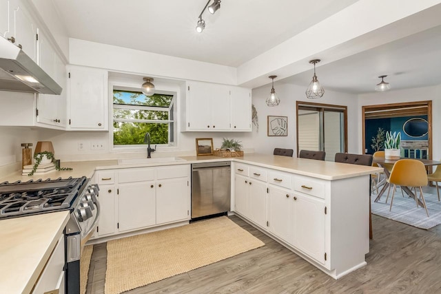 4951 W Joleno Ln, Brown Deer, WI 53223 - kitchen with stainless steel appliances, a peninsula, exhaust hood, and light wood-style flooring
