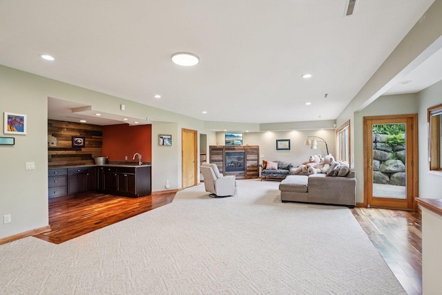7965 Westhill Cir, Verona, WI 53593 - living area with wood finished floors, a glass covered fireplace, recessed lighting, baseboards, and wet bar