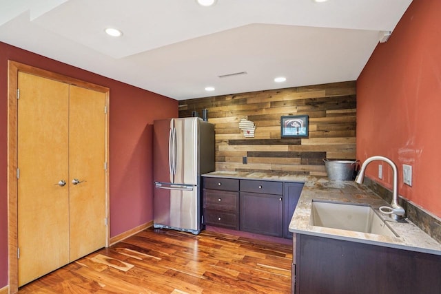 7965 Westhill Cir, Verona, WI 53593 - kitchen featuring freestanding refrigerator, a sink, light wood finished floors, recessed lighting, and wood walls