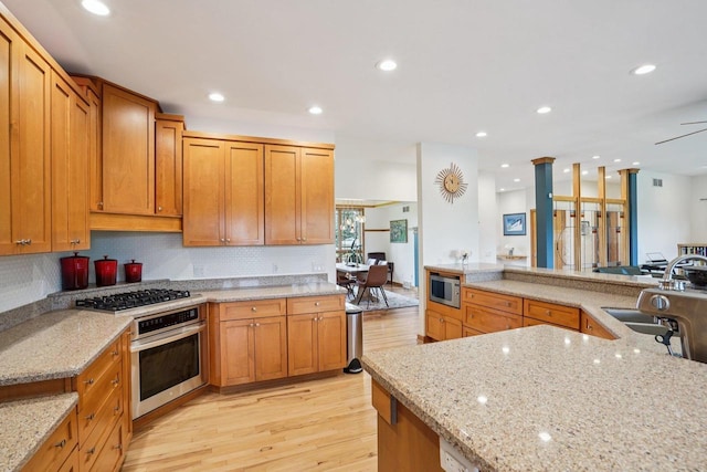 7965 Westhill Cir, Verona, WI 53593 - kitchen featuring appliances with stainless steel finishes, light wood-type flooring, a sink, decorative backsplash, and recessed lighting