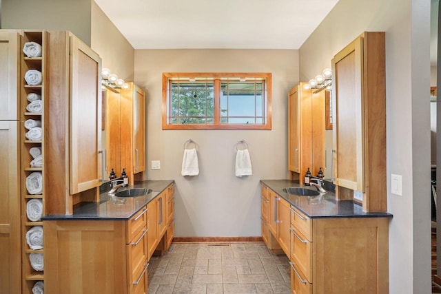7965 Westhill Cir, Verona, WI 53593 - bathroom featuring baseboards, two vanities, and stone tile floors