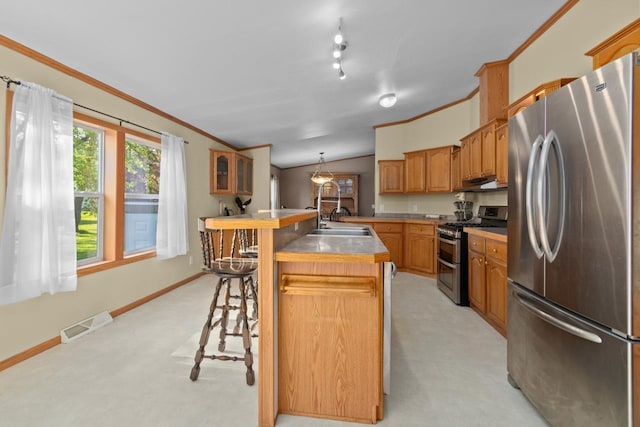 227 Cedar St, Ripon, WI 54971 - kitchen featuring stainless steel appliances, a sink, light colored carpet, a center island with sink, and a breakfast bar area